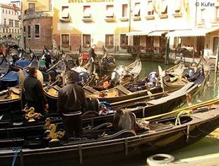 Am Ufer einer Gasse in Venedig sammeln sich Gondeln mit ihren Fahrern